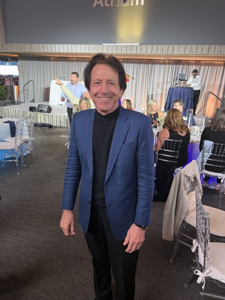 Portrait of fashion stylist Giuseppe wearing a blue blazer in an event setting.